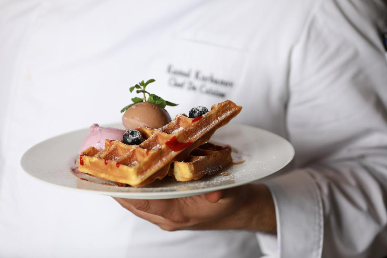 Hotel Hyatt Regency Taskent Exterior foto A waiter holding a plate of food